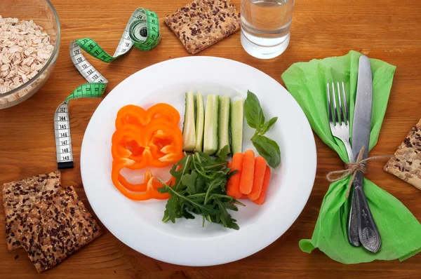 Concepto de dieta de alimentos. Desayuno de rúcula, zanahorias jóvenes y pepino. Cerca de harina de avena pan útil y un vaso de agua . —  Fotos de Stock