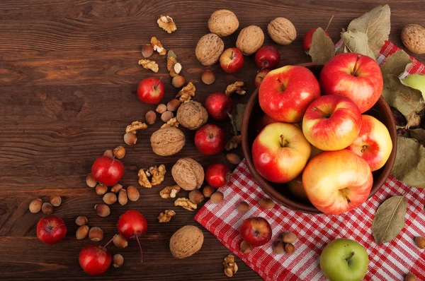 Natureza morta com maçãs de variedades diferentes, uvas e nozes em um contexto de madeira escuro. Conceito vegetariano — Fotografia de Stock