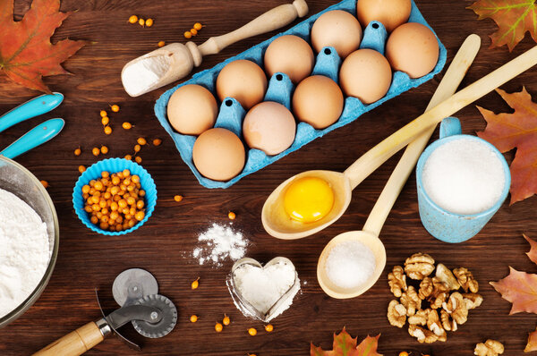 Ингредиенты для приготовления пищи и посуды на темном деревянном фоне
