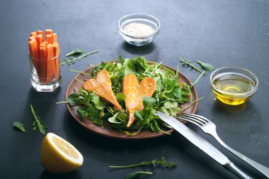 Concept diet food. Salad with arugula, leaf mash and carrots on a dark background. Vegetarian healthy dish that promotes weight loss.