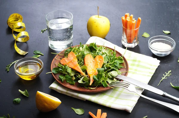 Konzept Diät Nahrung. Salat mit Rucola, Blattpüree und Karotten auf dunklem Hintergrund. Vegetarisches gesundes Gericht, das die Gewichtsabnahme fördert. — Stockfoto