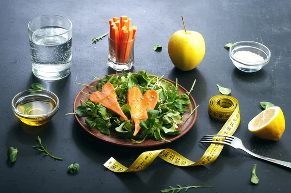 Concepto de dieta de alimentos. Ensalada con rúcula, puré de hojas y zanahorias sobre un fondo oscuro. Plato vegetariano saludable que promueve la pérdida de peso . —  Fotos de Stock