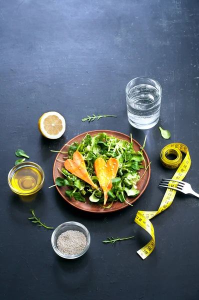 Conceptul de dietă. Salată cu arugula, piure de frunze și morcovi pe un fundal întunecat. Mâncare vegetariană sănătoasă care promovează pierderea în greutate . — Fotografie, imagine de stoc