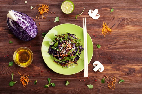 Concept diet food. Delicious vegetarian salad of arugula, leaf mash, purple cabbage and carrots on a brown wooden background. Natural organic healthy food, ready-to-eat — Stock Photo, Image