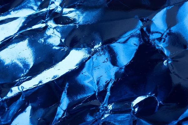 Crumpled blue foil paper texture.