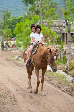 İki Asyalı kız at binme