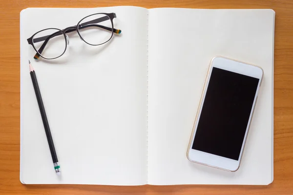 Anteojos, lápiz, celular, cuaderno — Foto de Stock