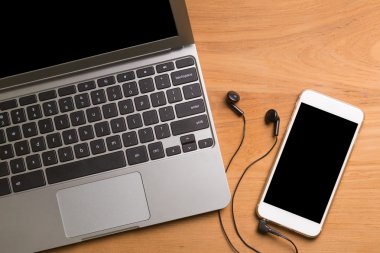 Bilgisayar laptop, smartphone, kulaklık, ahşap masa üzerinde