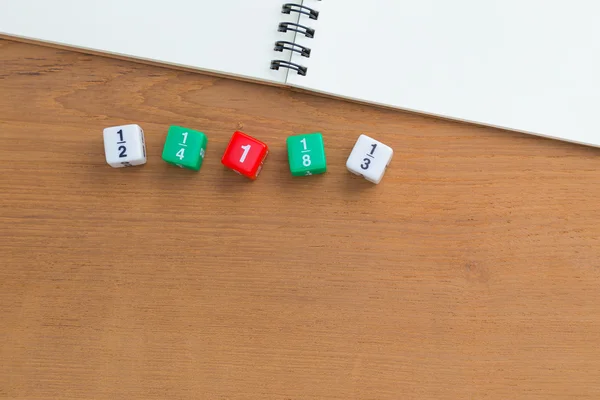 颜色分数骰子，木桌上的空白白色笔记本 — 图库照片