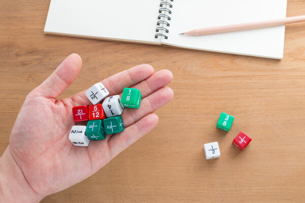 Рука держит цветные кубики
