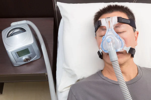 Homem asiático com apneia do sono usando máquina CPAP — Fotografia de Stock