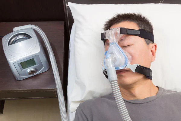 Homem asiático com apneia do sono usando máquina CPAP — Fotografia de Stock