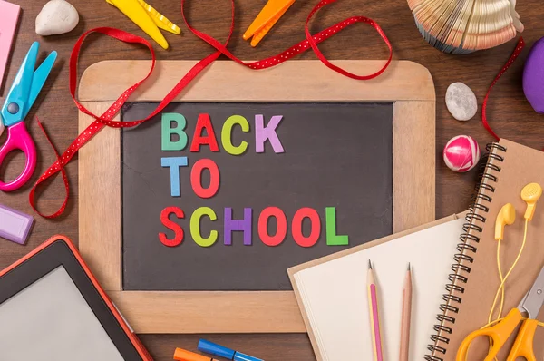 Stock image Back To School letters on small blackboard with school supplies