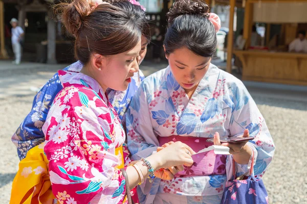 Japanse vrouwen in yugata lezen van fortuin papier — Stockfoto