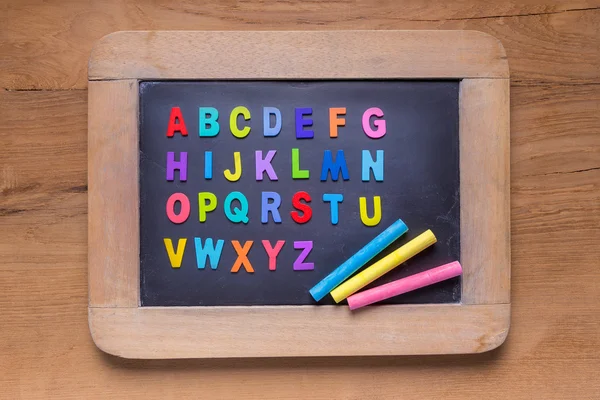 रंग चॉक और रंग अंग्रेजी वर्णमाला के साथ छोटा ब्लैकबोर्ड — स्टॉक फ़ोटो, इमेज