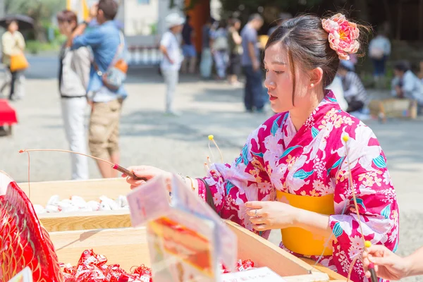 Japanse vrouw probeert haar geluk door het lokmiddel van geluk fortuin papieren vis — Stockfoto