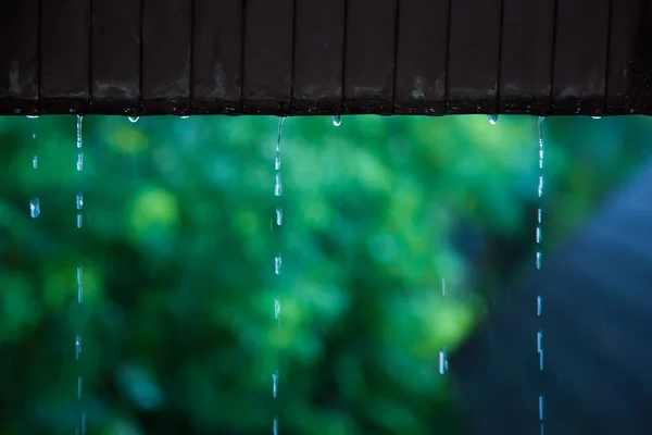 Капля дождевой воды со старой ржавой металлической крыши — стоковое фото