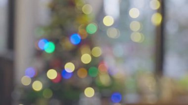 Büyük pencerenin yakınındaki Noel ağacında yanıp sönen Noel ışıkları, evde Noel için arka plan