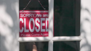 İş yeri kapalı tabelası, girişte asılı beyaz ahşap kapı, iş gününün başında açık tabelayla çevrilmek, ağır çekimde.