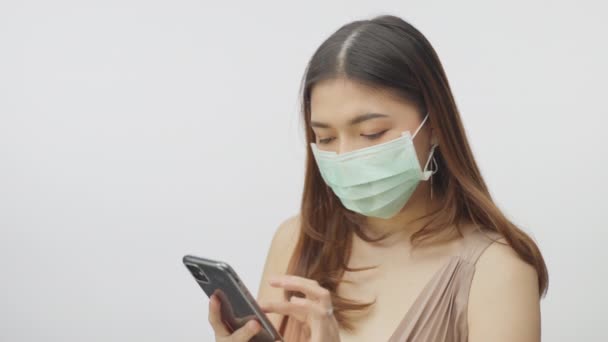 Young Woman Has Her Surgical Mask While Using Her Phone — Stock Video