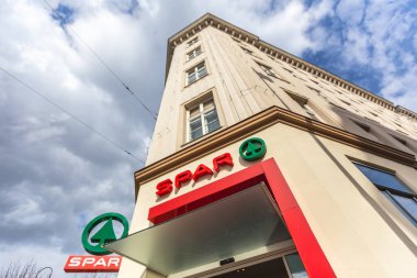 Viyana, Avusturya - 5 Nisan 2015 - Avusturya 'nın Viyana kentindeki bulutlu mavi gökyüzüne karşı Spar mağaza binasının dışı