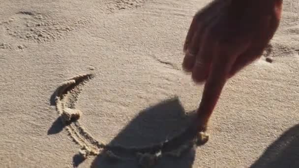 Žena čerpá srdce v písku — Stock video
