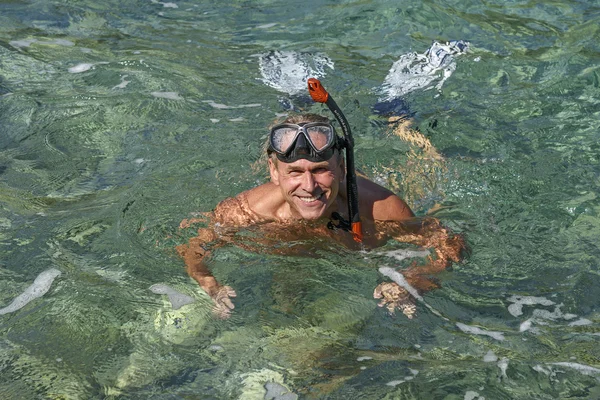 Uomo anziano che fa snorkeling con pinne, maschera e snorkeling nel Mare Adriatico. Apri la faccia sorridente. Paesaggio marino — Foto Stock
