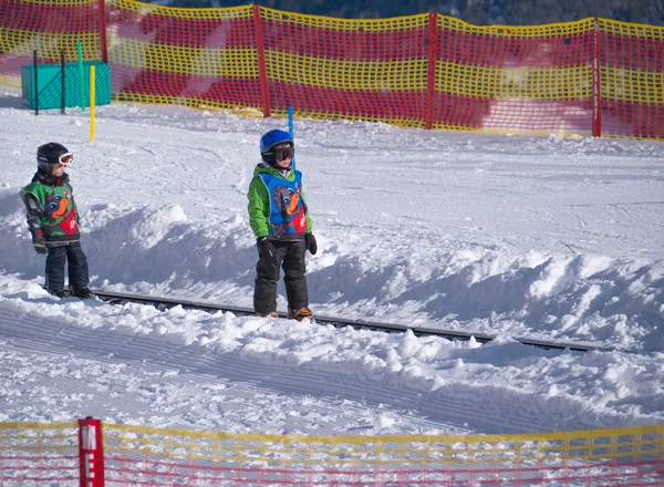 Два мальчика на ковре-самолете. Лыжная школа в Альпах, Австрия, Замс на 22 февраля 2015 г. — стоковое фото