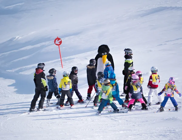 Skidlärare i en pingvin kostym studier barn i skidskola. Skidorten i Alperna, Österrike, Zams den 22 februari 2015 — Stockfoto