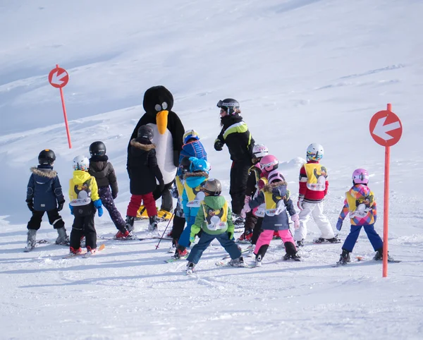 Skidlärare i pingvin kostym studerar barn. Skidorten i Alperna, Österrike, Zams den 22 februari 2015 — Stockfoto