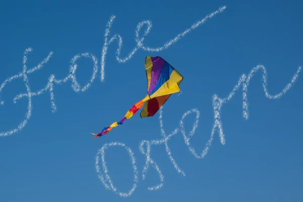 Felicidades Feliz Pascua de nubes en alemán con cometa de aire en el cielo azul brillante —  Fotos de Stock