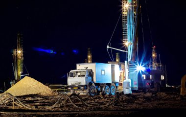 Drilling rig at night. clipart