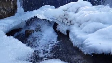 Buzun arasındaki bir dağ nehrinde su akıntısı.