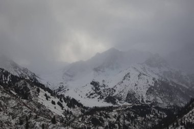 Kışın dağlarda bulutlarla kaplı manzara.