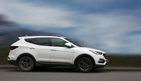 Bulanık doğal arka planda Hyundai beyaz arabası.