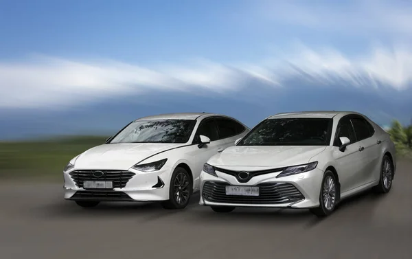 Bulanık arka planda beyaz arabalar hareket halinde.