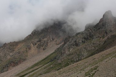 Tien Shan dağlarının bulutlu manzarası bir yaz günü.