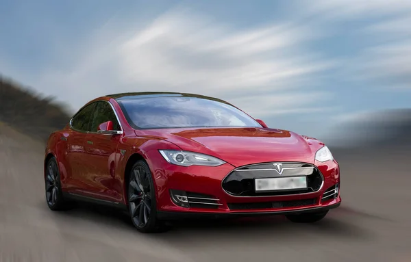 Hareket arka planında bulanık Tesla kırmızı arabası.