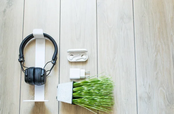 Üzerinde kulaklıklar bulunan tahta tahtalardan yapılmış natürmortlar ve beyaz ayaktadır.