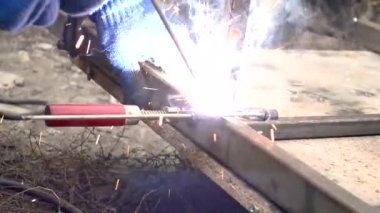 Açık bir alanda, bir elektrot ile kare metal boruların kaynaklanması