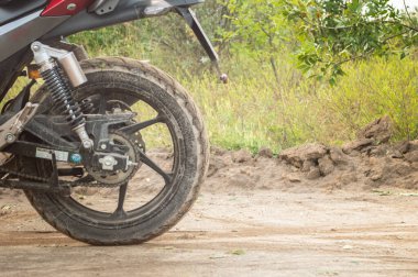 Toprak bir yolda, tarlada uzun bir yolculuk sırasında motosiklet.