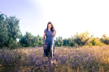 Bir sonbahar tarlasında elinde çiçeklerle bir kadının portresi