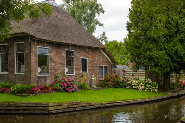 GIETHOORN, NETHERLANDS - evlerin ve bahçelerin tipik Hollanda ilçesi