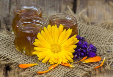 bal ve çiçekler - ahşap arka planda calendula ve lavanta