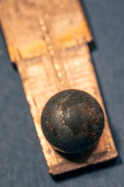 Bakır bir plaka üzerinde paslı bir bilyenin yakın çekimi. Alan fotoğrafçılığının düşük derinliği