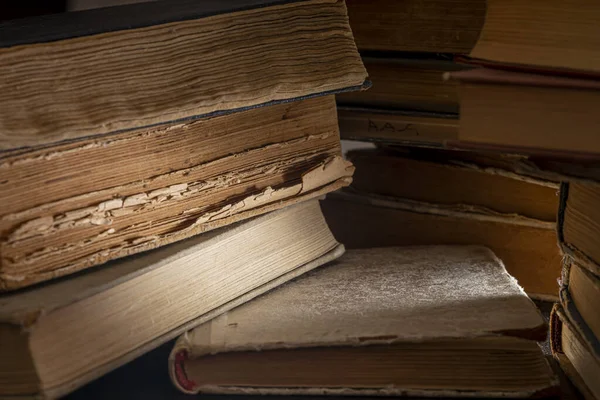 Stacks of old multi-format books with scuffs. Low depth of field photography