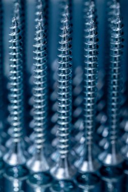 Ayna yüzeyinde galvanize edilmiş kendi kendine dokunan vidalar. Makro fotoğrafı vidalıyor. Yapı soyutlaması. Sanayi geçmişi.