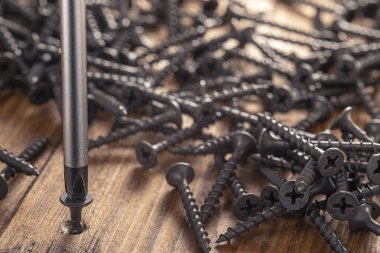 Tornavida ve tahta arka planda vida. Krom Vanadyum çelikten tornavida. Yapı soyutlaması. Sanayi geçmişi.