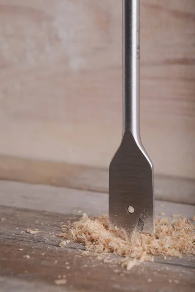 Feather wood drill bit on wooden background. Drill bit for wood on natural wood background. Woodworking background.