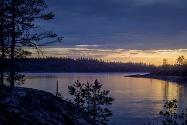 Bir adadan gün doğumu ve göl manzarası. Ladoga Gölü adalarında turizm.